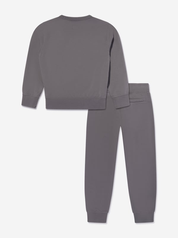 Elevate your young gentleman's ensemble with the CP Company Boys Logo Tracksuit in Grey. Expertly crafted for SS2025, this tracksuit is the pinnacle of luxury and utility. Iconic Lens Detail Celebrated CP Company lens on the sleeve adds a distinctive touch. Premium Comfort Constructed from superior quality fabrics, ensuring comfort during any activity. Subtle Branding Understated logo detailing offers a chic and elegant look. Versatile Style Ideal for both casual outings and stylish lounging at home.Refresh his wardrobe with flair sophistication! Order today.