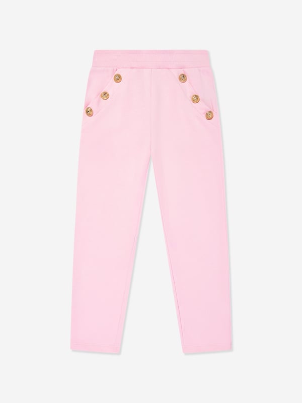 Balmain embody distinctive Parisian sensibilities in their immaculate designs. These girls pink gold joggers are reflective of the label's passion for raw innovation. Made in the finest cotton jersey with embellished gold buttons, a ribbed elasticated waistband, and front short side pockets. Straight Hem 100 Cotton Trim 95 Cotton, 5 Elastane
