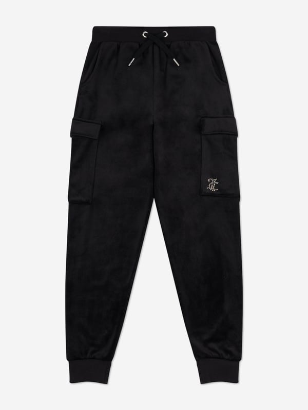 Introducing the Girls Cargo Cuffed Joggers in Black from Juicy Couture, a quintessential addition to your girl's wardrobe for SS2025. Elegantly tailored to blend sophistication with casual comfort, these joggers redefine childrens fashion. Key highlights include Luxe Comfort Crafted from premium fabric, ensuring softness durability. Chic Detailing Sleek cargo pockets cuffed ankles fuse functionality with style. Versatile Black Hue Perfect for seamless pairing with any top or accessory.Elevate your girls style quotient with these Joggers a symbol of modern chic!