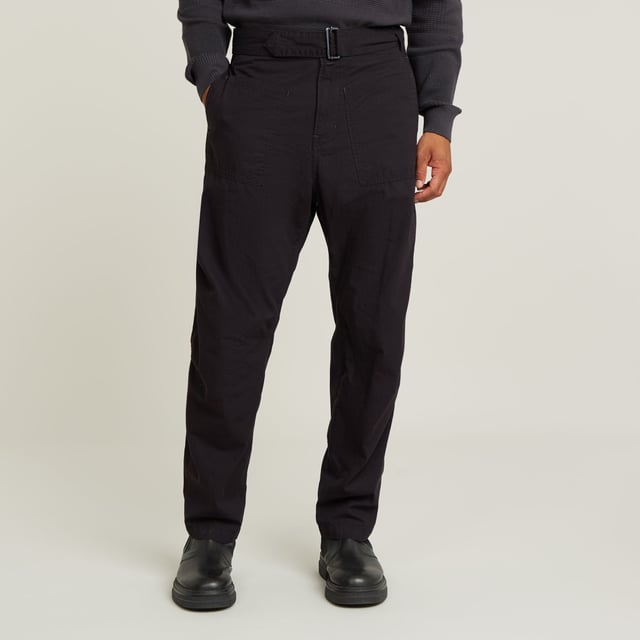 Zip fly. Side seam pockets, patched-on waist pockets. Flap pockets at the back, snap buttons. Belt. Adjustable leg width, tab. Button & zip closure. Mid waist. This Fatigue pant is designed in a relaxed tapered fit. The pleats at the side and the tabs at the ankle add to it. These pants combine side seam pockets with pockets at the front. The backside shows flap pockets with a snap button closure. Use the belt to finetune the fit. 100% Cotton. Rigid. Tapered