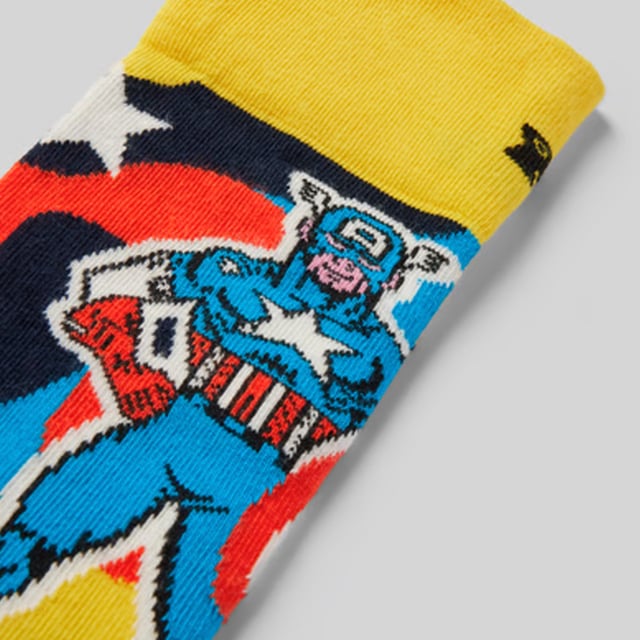 Happy Socks - Marvel Captain America Crew Socks: Step into the world of Marvel with the Captain America Crew Sock, a perfect tribute to the iconic superhero. Featuring a bold design inspired by Captain America’s shield, these socks are a must-have for Marvel fans. Crafted from a comfortable blend of organic cotton, polyamide, and elastane, they offer a snug fit that ensures all-day comfort. The reinforced heel and toe provide added durability, making them perfect for everyday wear. Whether you’re heading to the gym, running errands, or just lounging at home, these socks are designed to keep your feet cozy while showcasing your Marvel pride. Available in size 6-11, they offer a versatile fit for most foot sizes. . These Captain America socks are more than just a practical accessory—they’re a statement piece for Marvel enthusiasts. Add them to your collection or gift them to a fellow superhero fan. Perfect for any occasion, they combine comfort, style, and a love for Marvel heroes. Extra Product Details: Material: 73% Cotton, 25% Polyamide, 2% Elastane Size: 6-11 Design: Captain America shield theme Reinforced heel & toe for durability Care: Machine washable Ideal for: Marvel fans and superhero lovers. Embrace your Marvel spirit with these durable, stylish, and comfortable socks, perfect for everyday wear and a great addition to any Marvel collection!