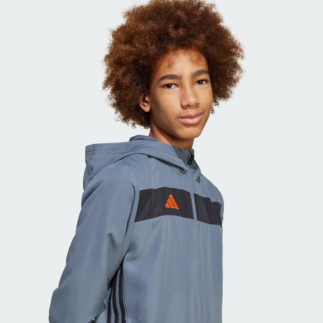 Look like a pro when you're off the field in this juniors' Tiro 25 Essentials hoodie from adidas. Inspired by the beautiful game, this hooded top brings football-inspired style to your everyday wear with bold blocks of colour, a 3 Bar Logo and a pair of signature 3-Stripes. Moisture-managing AEROREADY keeps you dry and comfortable, and two zip pockets secure your essentials.This product is made with 100% recycled materials. By reusing materials that have already been created, adidas help to reduce waste and our reliance on finite resources and reduce the footprint of the products adidas make.  - Regular fit - Full zip with hood - 100% polyester (recycled) - AEROREADY - Zip pockets  Shipped by adidas