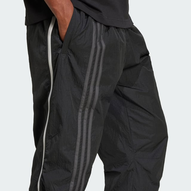 Inspired by the 2000s-era archive, these track pants from adidas give you a minimalist look with maximum impact. Long zippers along the sides with airy mesh underneath keep you comfortable with fashion in focus from the moment you pull them on. They have a loose fit with woven fabric that's lightweight yet durable. A floating Trefoil and 3-Stripes down the right leg show your allegiance to the brand with sport heritage.  - Loose fit - Drawcord on elastic waist - 100% polyamide (recycled) - Side-panel zips with mesh underneath  Shipped by adidas