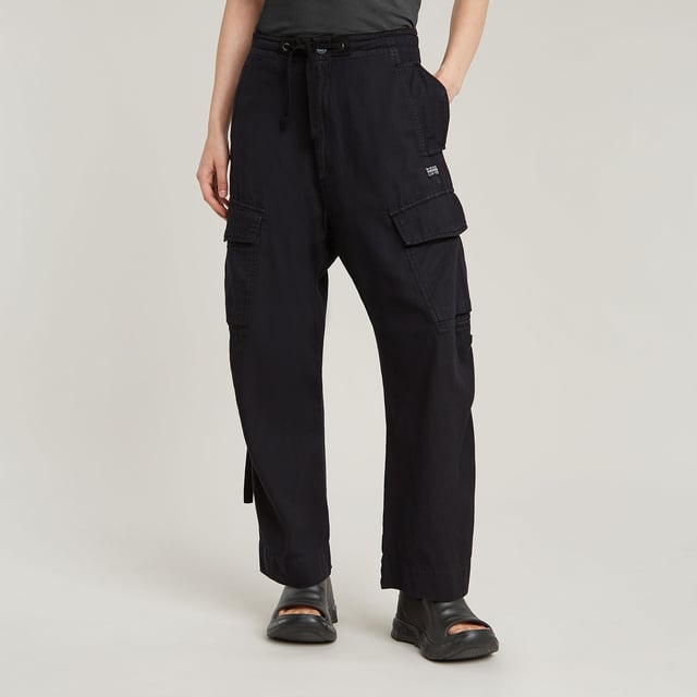 Zip fly and woven tape. Reversed flap pockets at the waist, flap pocket at the back, hidden snap buttons. Flap pockets with snap buttons at the side, straps at the edge. Option for tighter width at the ankle, close tab with snap button. Button & zip closure. High waist. Cargo pants Summer Snow are designed in a loose fit offering a zip fly with an additional drawcord. Waist pockets with a reverse flap offer a hidden snap button. Also at the thigh and back, flap pockets are created. The snaps at the ankles allow for a tighter cuff. 50% Cotton, 50% Recycled cotton. Rigid. Twill woven. Loose
