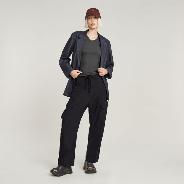 Zip fly and woven tape. Reversed flap pockets at the waist, flap pocket at the back, hidden snap buttons. Flap pockets with snap buttons at the side, straps at the edge. Option for tighter width at the ankle, close tab with snap button. Button & zip closure. High waist. Cargo pants Summer Snow are designed in a loose fit offering a zip fly with an additional drawcord. Waist pockets with a reverse flap offer a hidden snap button. Also at the thigh and back, flap pockets are created. The snaps at the ankles allow for a tighter cuff. 50% Cotton, 50% Recycled cotton. Rigid. Twill woven. Loose