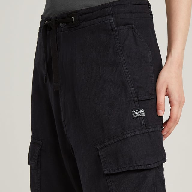 Zip fly and woven tape. Reversed flap pockets at the waist, flap pocket at the back, hidden snap buttons. Flap pockets with snap buttons at the side, straps at the edge. Option for tighter width at the ankle, close tab with snap button. Button & zip closure. High waist. Cargo pants Summer Snow are designed in a loose fit offering a zip fly with an additional drawcord. Waist pockets with a reverse flap offer a hidden snap button. Also at the thigh and back, flap pockets are created. The snaps at the ankles allow for a tighter cuff. 50% Cotton, 50% Recycled cotton. Rigid. Twill woven. Loose