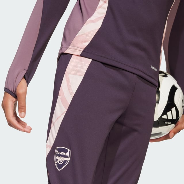 Show your fandom while you work on your fitness. These juniors' adidas Arsenal training pants will keep you feeling dry through every rep thanks to moisture-managing AEROREADY. The slim, tailored fit provides ease-of-movement for extra agility on the field. A club badge on the leg inspires your passion for football perfection.This product is made with 100% recycled materials. By reusing materials that have already been created, adidas help to reduce waste and our reliance on finite resources and reduce the footprint of the products adidas make.  - Slim fit - Drawcord on elastic waist - 100% polyester (recycled) - AEROREADY - Front zip pockets - Ankle zips - Arsenal heat-applied crest  Shipped by adidas