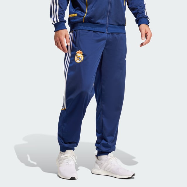 Real Madrid 99/00 Track Pants Relive a memorable European triumph in adidas Real Madrid track pants created to match those worn on the sidelines in the club's successful 99/00 season. Cut for a loose fit that's typical of 1990s football fashion, they layer easily over shorts. Woven onto the leg, that era-appropriate club badge supplies the perfect finish. - Loose fit - Elastic waist with drawcord - 100% polyester (recycled) - Front pockets - Real Madrid crest Shipped by adidas