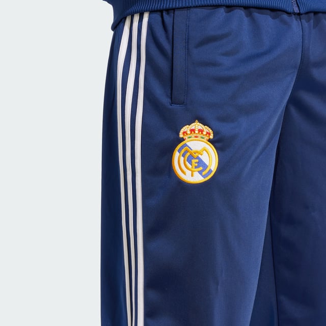 Real Madrid 99/00 Track Pants Relive a memorable European triumph in adidas Real Madrid track pants created to match those worn on the sidelines in the club's successful 99/00 season. Cut for a loose fit that's typical of 1990s football fashion, they layer easily over shorts. Woven onto the leg, that era-appropriate club badge supplies the perfect finish. - Loose fit - Elastic waist with drawcord - 100% polyester (recycled) - Front pockets - Real Madrid crest Shipped by adidas