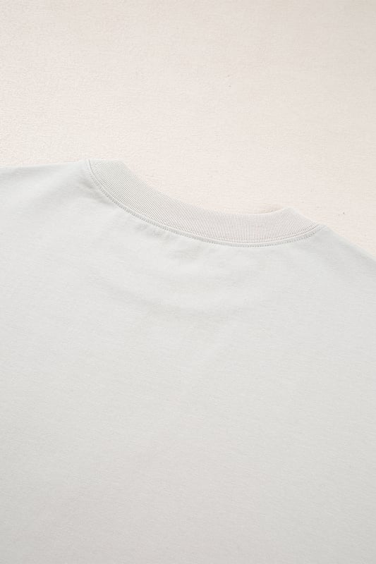 Auffälliges großes Schleifenmuster  
Übergrößenfit, geeignet für jede Körperform  
Entspanntes Design mit fallenden Schultern  
Tunikalänge für zusätzlichen Schutz  
Material: 95% Baumwolle, 5% Elasthan