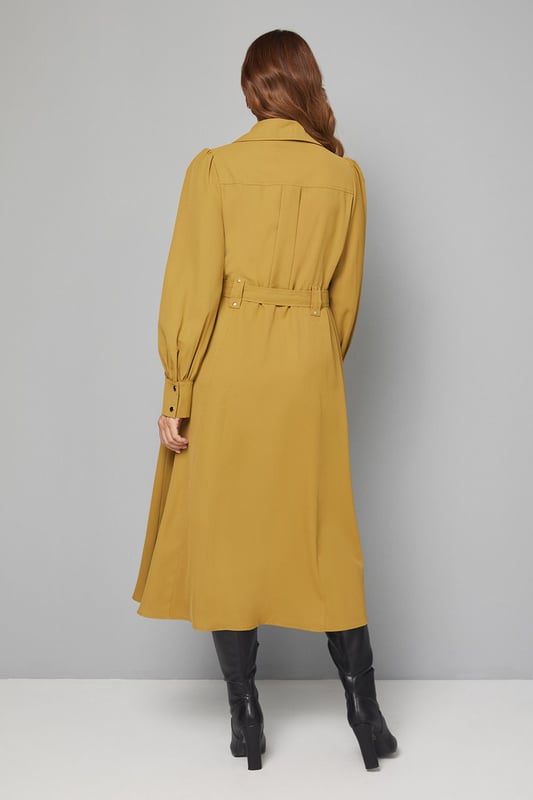 Elegant midi dress crafted from lightweight crepe fabric for comfortable all-day wear
        Sophisticated collared neckline with button-through front design for classic appeal
        Statement balloon sleeves with neat cuffs adding a contemporary touch to a timeless silhouette
        Practical chest pockets providing both style and functionality
        Flattering belted waist that cinches and defines your figure beautifully
    
    This versatile Wallis midi dress combines sophistication with everyday wearability. The flowing crepe fabric drapes elegantly while the belted waist creates a flattering silhouette that works for various body types. Style with knee-high boots as shown for an effortlessly chic daytime look perfect for lunch dates or family gatherings. For a more casual approach, pair with white trainers and a denim jacket. The practical pocket details and comfortable fit make this an ideal choice for busy days when you need to look polished without sacrificing comfort. Transition from day to evening by swapping boots for ballet flats and adding statement earrings. This dress will quickly become a cornerstone of your wardrobe, offering endless styling possibilities throughout the seasons.