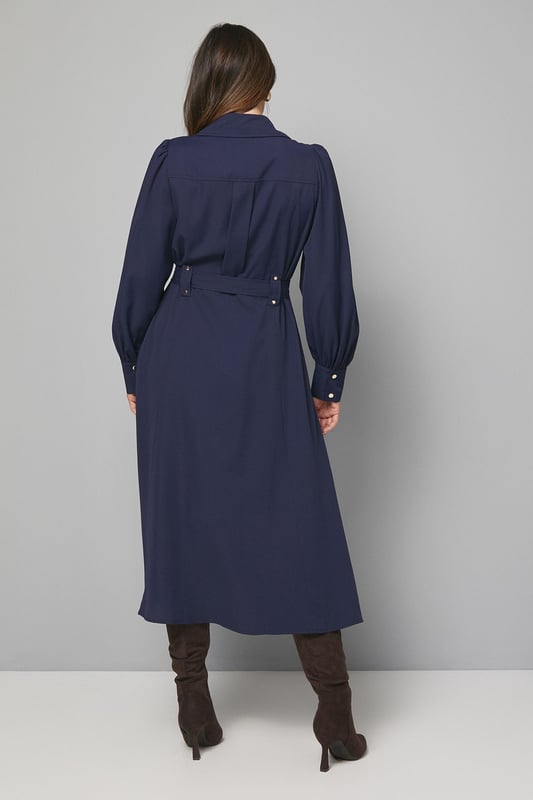 Elegant midi dress crafted from lightweight crepe fabric for comfortable all-day wear
        Sophisticated collared neckline with button-through front design for classic appeal
        Statement balloon sleeves with neat cuffs adding a contemporary touch to a timeless silhouette
        Practical chest pockets providing both style and functionality
        Flattering belted waist that cinches and defines your figure beautifully
    
    This versatile Wallis midi dress combines sophistication with everyday wearability. The flowing crepe fabric drapes elegantly while the belted waist creates a flattering silhouette that works for various body types. Style with knee-high boots as shown for an effortlessly chic daytime look perfect for lunch dates or family gatherings. For a more casual approach, pair with white trainers and a denim jacket. The practical pocket details and comfortable fit make this an ideal choice for busy days when you need to look polished without sacrificing comfort. Transition from day to evening by swapping boots for ballet flats and adding statement earrings. This dress will quickly become a cornerstone of your wardrobe, offering endless styling possibilities throughout the seasons.