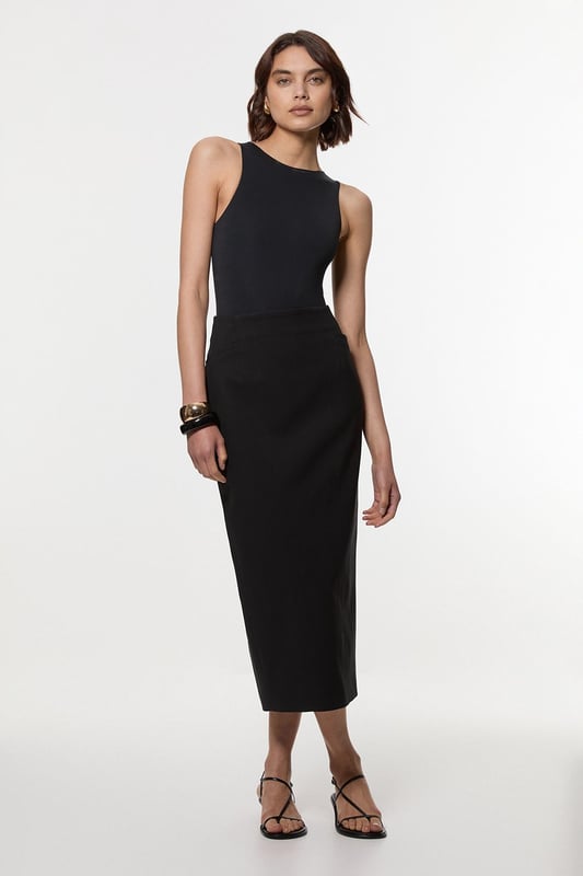 This Karen Millen tailored midi pencil skirt offers the perfect balance of sophistication and practicality for your everyday wardrobe. The compact stretch fabric moulds to your silhouette whilst ensuring all-day comfort and ease of movement. Style with a crisp sleeveless top and strappy sandals for a refined daytime look, or pair with a structured blazer for an effortlessly stylish ensemble perfect for family gatherings or lunch with friends. The functional pocket detail adds a contemporary touch to this timeless piece, whilst the below-knee length creates a flattering line that works brilliantly with both flats and low heels. This versatile skirt can be dressed down with a casual knit and trainers for weekend brunches or styled with a silk blouse for more polished daywear occasions.  Sleek midi pencil skirt Practical side pocket detail Elegant midi length Versatile design