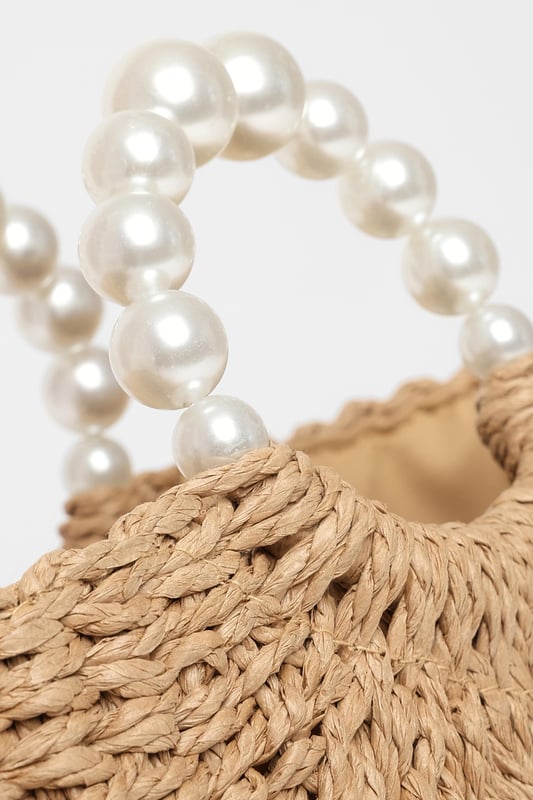 - Woven finish - Pearl details - Top handle - Lined - Exterior: 100% paper; excluding trims - Lining: 100% polyester
