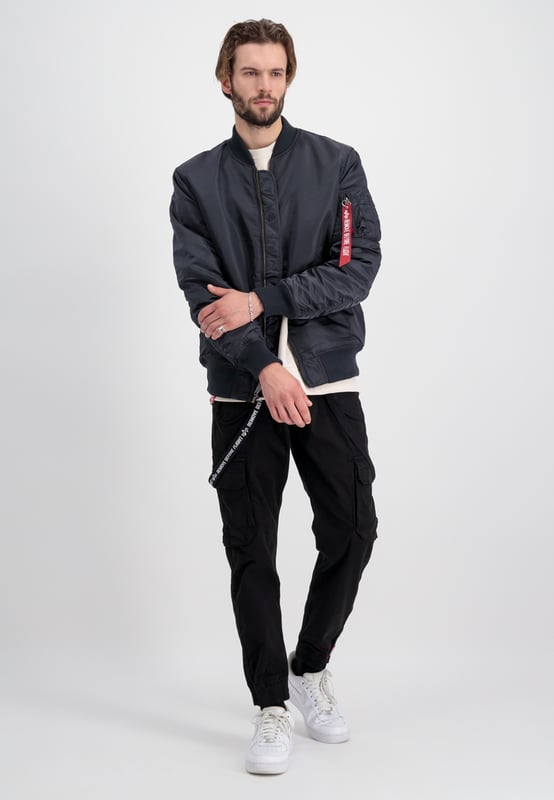We present the MA-1 VF 59 Long bomber jacket from Alpha Industries. This stylish and comfortable jacket is perfect for men who desire a slim fit with a longer cut. It features an orange lining and a pencil pocket for added convenience.