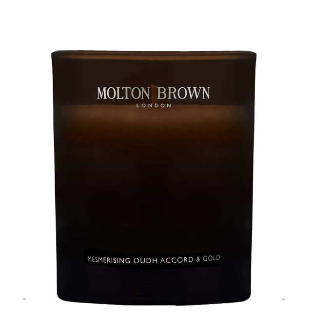 Luxurious Molton Brown Oudh Accord & Gold Candle - 190g Indulge in the opulent aroma of the Molton Brown Oudh Accord & Gold Candle, expertly crafted to elevate your space. Launched in 2015, this enchanting candle features a harmonious blend of spicy top notes of cinnamon leaf, nutmeg, and bergamot, complemented by rich middle notes of elemi, myrrh, and black tea. The warm base notes of oudh, vetiver, and honey create a truly captivating experience. Each candle is 190g and embodies the cruelty-free ethos of the Leaping Bunny approved Molton Brown brand, making it an exquisite gift or self-care treat.