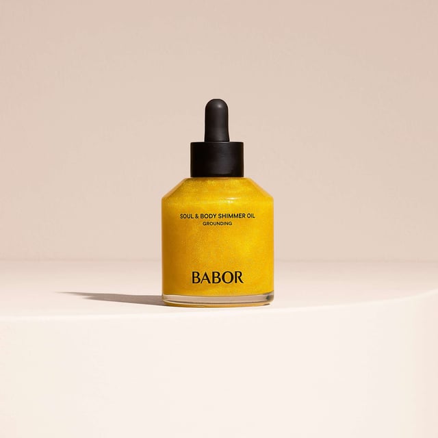 Experience the luxurious BABOR Soul & Body Shimmer Oil, designed to rejuvenate your skin and senses. This exquisite body oil features radiant glow particles enveloped in nourishing oils that melt effortlessly into your skin, leaving a stunningly beautiful complexion. Infused with essential oils and a warm, elegant fragrance, it promotes harmony and balance for a moment of pure indulgence. Enriched with oat kernel oil, rich in vitamin E, this oil protects against moisture loss and enhances your skin barrier. Shake well before use, apply to skin, and massage gently.
