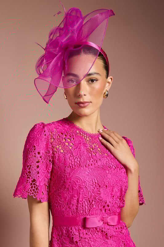 Exquisite lace midi dress with intricate floral pattern
        Elegant bow belt accentuates the waistline
        Flattering round neckline and short sleeves
        Scalloped hem adds a delicate touch
        Midi length perfect for formal occasions
    
    This stunning lace midi dress radiates sophistication and grace, making it an ideal choice for weddings, races, or any formal event where you want to make a lasting impression. The intricate floral lace pattern adorns the entire dress, creating a romantic and feminine silhouette. The bow belt cinches the waist beautifully, enhancing your figure and adding a charming detail. Style this dress with a matching fascinator, as shown, for a coordinated look that's sure to turn heads. Pair with strappy metallic heels and a clutch bag to complete your ensemble. For cooler evenings, drape a lightweight pashmina over your shoulders. This versatile piece can be dressed up or down, making it a valuable addition to your occasion wear wardrobe.