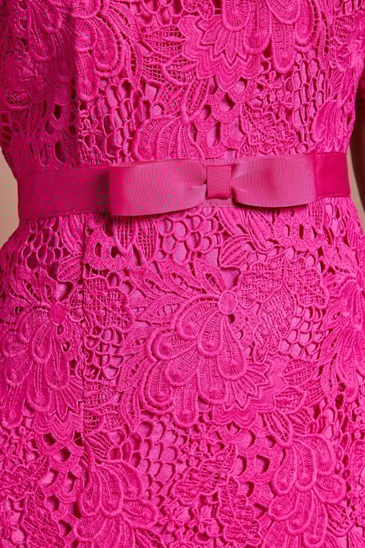 Exquisite lace midi dress with intricate floral pattern
        Elegant bow belt accentuates the waistline
        Flattering round neckline and short sleeves
        Scalloped hem adds a delicate touch
        Midi length perfect for formal occasions
    
    This stunning lace midi dress radiates sophistication and grace, making it an ideal choice for weddings, races, or any formal event where you want to make a lasting impression. The intricate floral lace pattern adorns the entire dress, creating a romantic and feminine silhouette. The bow belt cinches the waist beautifully, enhancing your figure and adding a charming detail. Style this dress with a matching fascinator, as shown, for a coordinated look that's sure to turn heads. Pair with strappy metallic heels and a clutch bag to complete your ensemble. For cooler evenings, drape a lightweight pashmina over your shoulders. This versatile piece can be dressed up or down, making it a valuable addition to your occasion wear wardrobe.