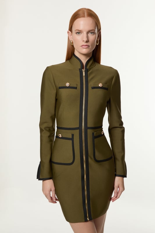Feel elegant in our mini dress, with a figure hugging silhouette, trim detailing, and contrasting metallic hardware. Style this dress with tiights and heels for an outfit that will turn heads from office days to upcoming occasions and events. Figure Form Bandage Knit Piping Detail Military Dress High Quality Knit Fabric Contrasting, Piped Detailing Metallic Hardware Accents Flattering Fit and Flare Silhouette Formal High Neckline Bodycon Silhouette Zip Front Fastening