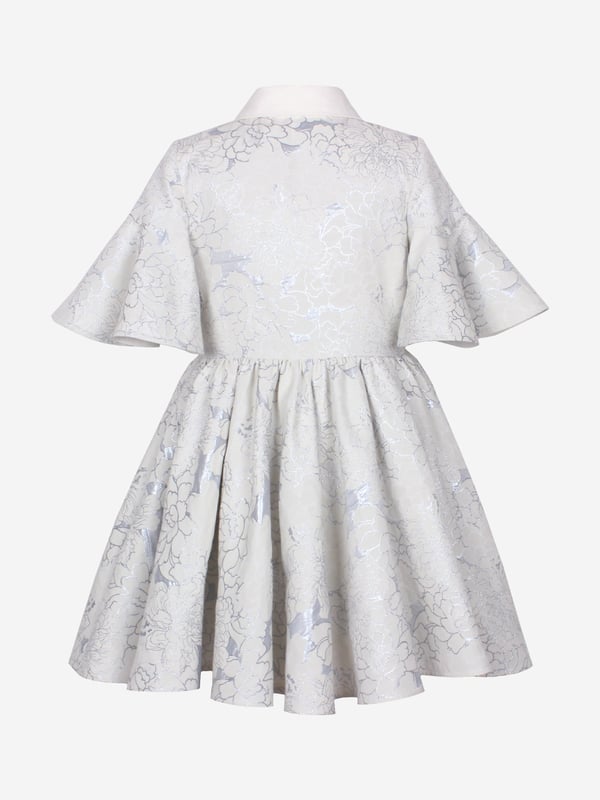 Jessie and James embody timeless elegance and modern charm. Crafted with a sophisticated jacquard floral print, this girls little sister blue clouds jacquard dress combines classic style with contemporary flair. Woven in ice blue. It showcases a front button fastening, classic collar, flared cuffs, and an elegant peplum hem. Outer Polyester 50, Cotton 39, Metallic Fibre 11 Lining Cotton 100