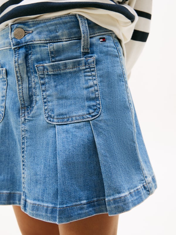 Tommy Hilfiger Girls Pleated Denim Skirt in Blue Introducing the Tommy Hilfiger Girls Pleated Denim Skirt in Blue an essential addition for SS2025. Crafted with flair, this skirt encapsulates both comfort and fashion for your young one. Key features include Classic Pleated Design Chic pleats merge timeless style with a fresh, youthful twist. Vibrant Blue Hue A striking blue shade complements any top, ensuring versatility across seasons. Quality Denim Fabrication Durably constructed to withstand the joys of childhood. Signature Branding Embellished with the iconic Tommy Hilfiger logo for an exquisite touch.Revitalize your girl's wardrobe with this delightful, versatile piece.