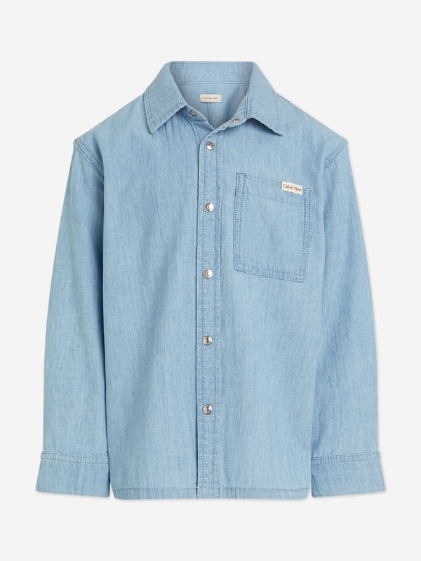 Introducing the Boys Relaxed Chambray Shirt in Blue by Calvin Klein, the quintessential blend of sophistication and comfort for SS2025. Ideal for every young gentleman's wardrobe, this shirt promises both style and ease. Key features include Classic Chambray Crafted with premium cotton chambray, ensuring a soft and breezy feel perfect for sunny days. Versatile Blue Hue A deep, versatile blue that complements any outfit, ideal for both casual and formal occasions. Signature Detailing Enhanced with Calvin Klein's discreet branding, adding a touch of exclusive luxury. Easy Care Machine washable and resilient, designed for the effortless upkeep required by every young adventurer.Elevate your boy's style with this timeless piece from Calvin Klein. Order now to capture the essence of SS2025!