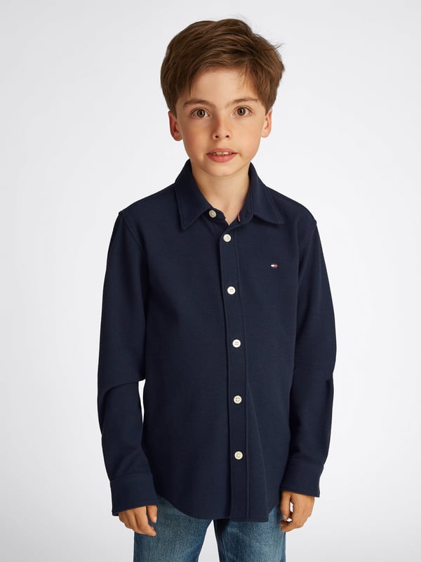 Discover the Boys Micro Waffle Regular Shirt in Navy by Tommy Hilfiger, an impeccable addition to your boy's wardrobe for SS2025. Elegantly designed, this piece merges classic style with contemporary touches. Key features include Exquisite Micro Waffle Texture Delivers a sophisticated look while ensuring breathability and comfort. Classic Navy Hue Versatile and timeless, perfect for any occasion. Superior Craftsmanship Attention to detail in stitching and finishes reflects high-end quality. Elevate your boy's style quotient with this stylish and durable shirt. Shop now!