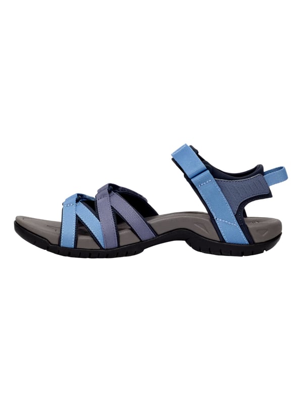 Teva wandelsandalen De Teva TIRRA sandaal is een veelzijdige trekking sandaal die speciaal is ontwikkeld voor actieve dagen en warme temperaturen. Het functionele ontwerp biedt niet alleen lichtheid en bewegingsvrijheid, maar ook het comfort dat wordt gewaardeerd op langere afstanden. De eenvoudige klittenbandsluiting maakt het snel aan- en uittrekken mogelijk en zorgt voor een nauwkeurige pasvorm die zich perfect aanpast aan de voet. Bij elke stap voel je het dempende effect van de geïntegreerde Shoc Pad™ in de hiel, die stuitert waar dat het meest nodig is en je loopbeweging aangenaam dempt. De fijn geprofileerde buitenzool biedt stevige grip, zelfs op wisselende ondergronden, terwijl het gestructureerde voetbed en de gerichte ondersteuning van de voetboog ervoor zorgen dat de voet zelfs op lange tochten comfortabel blijft. De TIRRA combineert dus sportieve alledaagsheid met betrouwbare ondersteuning en langdurig comfort - ideaal voor iedereen die in stijl wil blijven bewegen en goed voorbereid wil zijn.