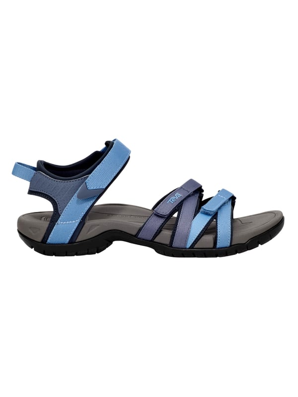 Teva wandelsandalen De Teva TIRRA sandaal is een veelzijdige trekking sandaal die speciaal is ontwikkeld voor actieve dagen en warme temperaturen. Het functionele ontwerp biedt niet alleen lichtheid en bewegingsvrijheid, maar ook het comfort dat wordt gewaardeerd op langere afstanden. De eenvoudige klittenbandsluiting maakt het snel aan- en uittrekken mogelijk en zorgt voor een nauwkeurige pasvorm die zich perfect aanpast aan de voet. Bij elke stap voel je het dempende effect van de geïntegreerde Shoc Pad™ in de hiel, die stuitert waar dat het meest nodig is en je loopbeweging aangenaam dempt. De fijn geprofileerde buitenzool biedt stevige grip, zelfs op wisselende ondergronden, terwijl het gestructureerde voetbed en de gerichte ondersteuning van de voetboog ervoor zorgen dat de voet zelfs op lange tochten comfortabel blijft. De TIRRA combineert dus sportieve alledaagsheid met betrouwbare ondersteuning en langdurig comfort - ideaal voor iedereen die in stijl wil blijven bewegen en goed voorbereid wil zijn.