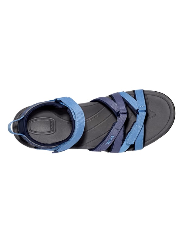 Teva wandelsandalen De Teva TIRRA sandaal is een veelzijdige trekking sandaal die speciaal is ontwikkeld voor actieve dagen en warme temperaturen. Het functionele ontwerp biedt niet alleen lichtheid en bewegingsvrijheid, maar ook het comfort dat wordt gewaardeerd op langere afstanden. De eenvoudige klittenbandsluiting maakt het snel aan- en uittrekken mogelijk en zorgt voor een nauwkeurige pasvorm die zich perfect aanpast aan de voet. Bij elke stap voel je het dempende effect van de geïntegreerde Shoc Pad™ in de hiel, die stuitert waar dat het meest nodig is en je loopbeweging aangenaam dempt. De fijn geprofileerde buitenzool biedt stevige grip, zelfs op wisselende ondergronden, terwijl het gestructureerde voetbed en de gerichte ondersteuning van de voetboog ervoor zorgen dat de voet zelfs op lange tochten comfortabel blijft. De TIRRA combineert dus sportieve alledaagsheid met betrouwbare ondersteuning en langdurig comfort - ideaal voor iedereen die in stijl wil blijven bewegen en goed voorbereid wil zijn.