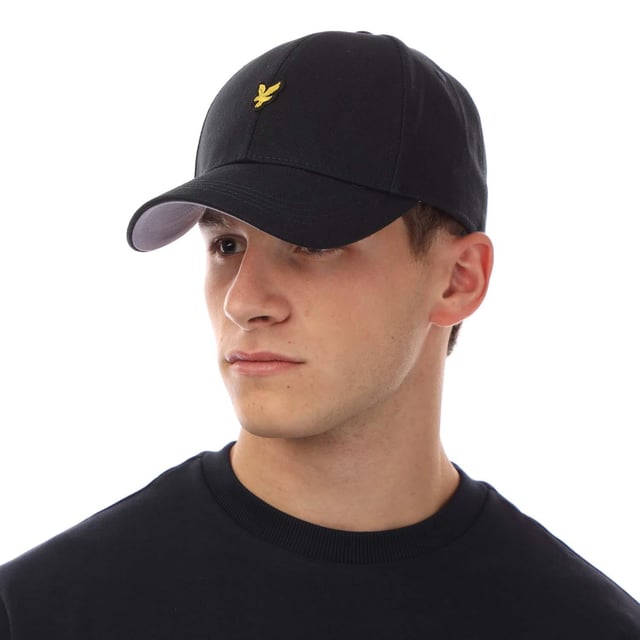 Außenmaterial (%): 100% Baumwolle. Marke: Lyle & Scott. Gewebe: Schwerer Köperstoff. Design: Gesticktes Logo. Design mit 6 Segmenten, Oben mit Knopf, Abgerundeter Kopf, Mit umstickten Ösenlöchern, Genähte Krempe. Verstellbarer Gurt.