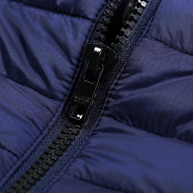Shell: Nylon, Polyester. Voering: 100% polyester. Vulling: Gerecycleerd. Stof: Softshell. Ontwerp: Geborduurd logo, Gewatteerd. Binddetail, voorstuk, gewatteerd. Halslijn: Kapitein. Mouwtype: Mouwloos. Zakken: 2 Zijzakken, Rits. Sluiting: Volledige ritssluiting, Vislon ritssluiting. XS: 36 in. S: 38 in. M: 40 in.