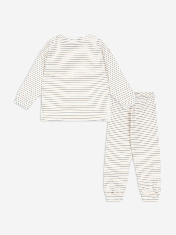Konges Sløjd incorporate beautiful, eco-friendly technology into their charming aesthetics. This boys stripe blue pyjama set consists of a nightgown and a pair of night trousers in white with narrow, blue stripes. The nightgown has a golden print of a moon and a cute brown bear holding a cushion. The matching trousers come with an elastic edge at the waist to provide the utmost comfort. Nightgown Round Neckline, Long Sleeves, Wide Edges Trousers Wide Edges 100 Organic Cotton