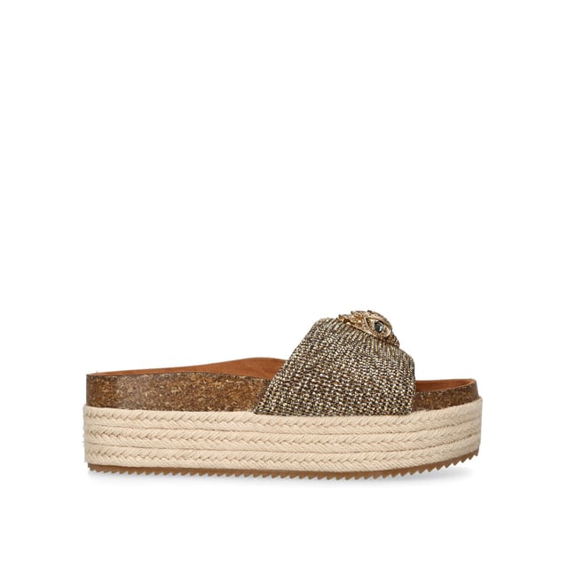 The Kensington Flatform, an addition to the Kensington Collection, features a houndstooth strap embellished with gold crystals. The gold Eagle head features crystals and black crystal eyes on the strap. Sole height: 4cm.