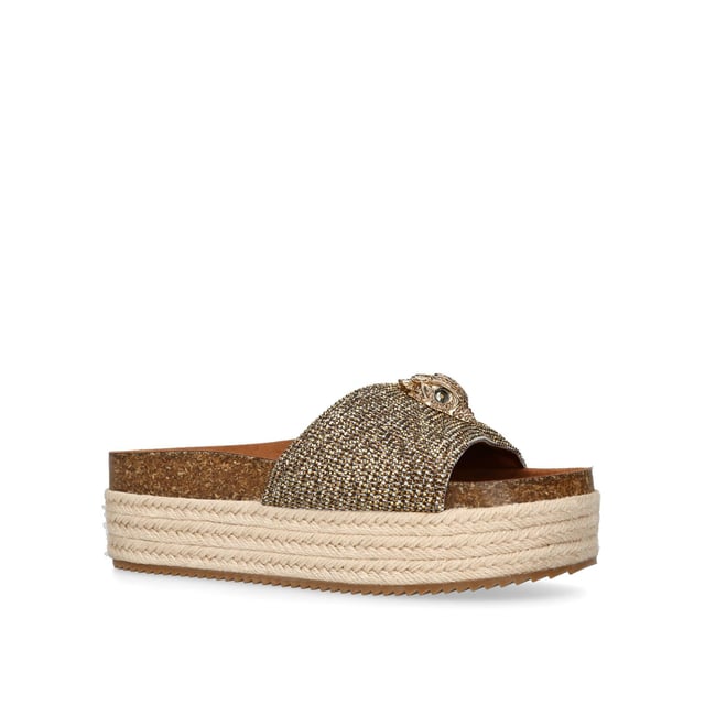 The Kensington Flatform, an addition to the Kensington Collection, features a houndstooth strap embellished with gold crystals. The gold Eagle head features crystals and black crystal eyes on the strap. Sole height: 4cm.
