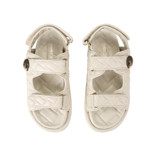 The Kurt Geiger Orson sandal features a bone soft upper with weave quilting pattern. The straps are velcro with an antiqued brass eagle head emblem sat on top. Over stitched quilted insole with padding, seen across the collections.