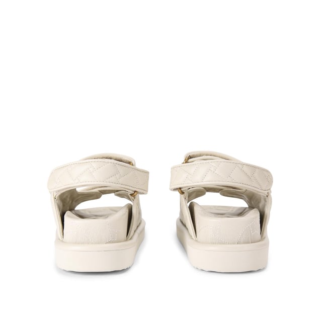 The Kurt Geiger Orson sandal features a bone soft upper with weave quilting pattern. The straps are velcro with an antiqued brass eagle head emblem sat on top. Over stitched quilted insole with padding, seen across the collections.
