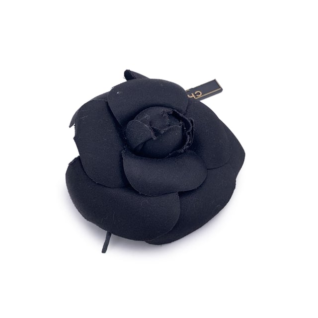 Chanel Vintage Cloth Brooch Camelia VINTAGE, RRP AS NEW
Chanel Vintage Camellia Flower Pin Brooch - Black Satin Timelessly feminine and unmistakably Chanel, this Vintage Camellia Flower Pin Brooch captures the Maison's enduring love for the iconic camellia bloom - a signature symbol of elegance and grace. Crafted from luxurious black satin, the layered petals create a soft yet sculptural silhouette that adds depth and dimension to any ensemble. Measuring approximately 4 inches (10.2 cm) in diameter, this striking brooch is designed to make a subtle yet refined statement. The piece secures with a classic safety pin closure, allowing it to be effortlessly styled on a lapel, hat, scarf, or handbag. On the reverse, the brooch is finished with the signature 'CHANEL - CC - Made in France' oval ity tab, affirming its heritage and craftsmanship. A true collector's piece, the Camellia Brooch brings vintage charm and Parisian sophistication to any look - elegant, understated, and eternally chic. Condition Rating: A - EXCELLENTCondition Details: Gently used. Chanel box included. Please check the photos carefully and ask if you need to know more details or if you have any doubts. Box?: ?: Yes Measurments: length: 102 mm strap length: 0 mm handle drop: 0 mm