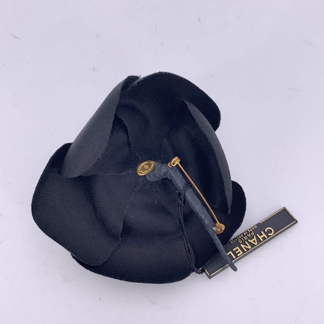 Chanel Vintage Cloth Brooch Camelia VINTAGE, RRP AS NEW
Chanel Vintage Camellia Flower Pin Brooch - Black Satin Timelessly feminine and unmistakably Chanel, this Vintage Camellia Flower Pin Brooch captures the Maison's enduring love for the iconic camellia bloom - a signature symbol of elegance and grace. Crafted from luxurious black satin, the layered petals create a soft yet sculptural silhouette that adds depth and dimension to any ensemble. Measuring approximately 4 inches (10.2 cm) in diameter, this striking brooch is designed to make a subtle yet refined statement. The piece secures with a classic safety pin closure, allowing it to be effortlessly styled on a lapel, hat, scarf, or handbag. On the reverse, the brooch is finished with the signature 'CHANEL - CC - Made in France' oval ity tab, affirming its heritage and craftsmanship. A true collector's piece, the Camellia Brooch brings vintage charm and Parisian sophistication to any look - elegant, understated, and eternally chic. Condition Rating: A - EXCELLENTCondition Details: Gently used. Chanel box included. Please check the photos carefully and ask if you need to know more details or if you have any doubts. Box?: ?: Yes Measurments: length: 102 mm strap length: 0 mm handle drop: 0 mm