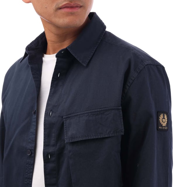 Point collar.Long sleeve.Centre front button fastening.Signature tilted flap pocket.Adjustable buttoned cuff.Belstaff Phoenix patch on sleeve.Garment-dyed cotton twill.