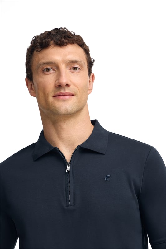 Werten Sie Ihren Stil mit unserem Poloshirt Esko auf, das für den anspruchsvollen urbanen Mann entworfen wurde. Dieses Kurzarm- Poloshirt bietet Komfort und Stil und eignet sich für eine Vielzahl von Anlässen. Regular Fit. Der Polokragen mit verdecktem Metallreißverschluss verleiht einen Hauch von Raffinesse. Gerippte Abschlüsse an Kragen, Ärmeln und Saum sorgen für eine optimale Passform. Das gestickte PC-Monogramm auf der Brust rundet das Design ab. Dieses Poloshirt ist ideal für einen lässigen Look mit Jeans oder für einen eleganteren Look mit Chinohose.