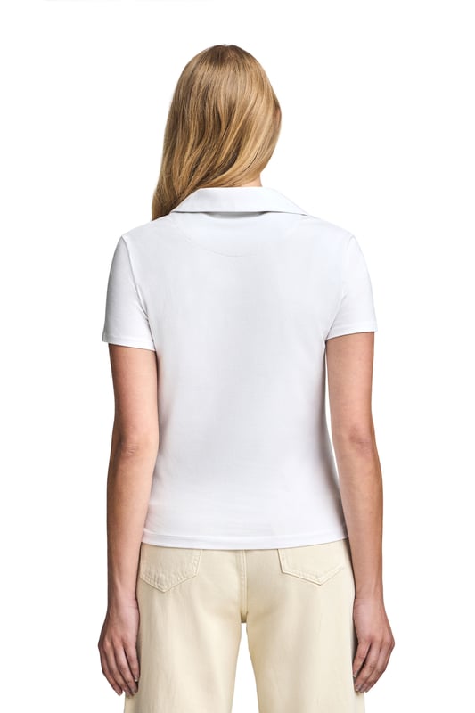 Poloshirt Pedraza knopflos weiß mit gummiertem Polo Club Logo Das Damen-Poloshirt Pedraza aus Baumwolle zeichnet sich durch seine weiche, elegante Textur aus. Der Polokragen mit V-Ausschnitt sorgt für eine klassische Silhouette mit lässigem Charakter. Zwei Seitenschlitze sorgen für zusätzliche Bewegungsfreiheit. Ton-in-Ton-Detail an der Innenseite des Kragens. Das gummierte Polo Club Logo auf der Brust verleiht diesem Poloshirt einen besonderen Touch und macht es zu einer perfekten Wahl für jede Gelegenheit, von einem Freizeitausflug bis hin zu eleganteren Anlässen.
