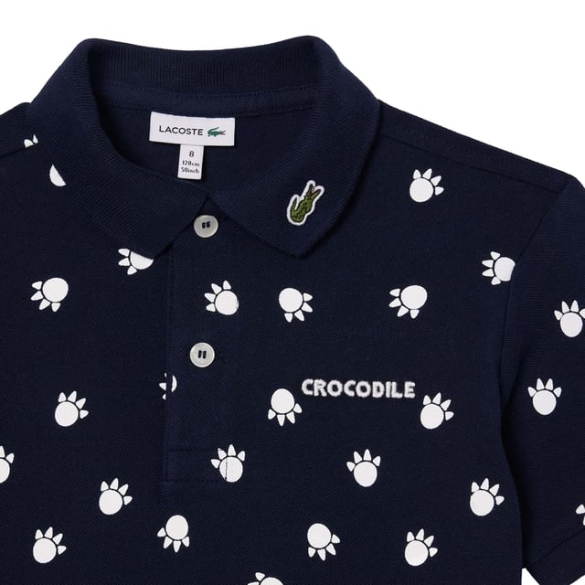 100% biologisch katoen. Stof: Pique. Ontwerp: Overal bedrukt, Geborduurd, Logo. Bevestiging: knop, pullover. Halslijn: Collared, Ribbed. Mouwtype: Korte mouwen. Knoopsluiting met 2 knopen. 2 jaar: 20 in. 3 Jaar: 21 in. 4 Jaar: 22 in. 12 Jaar: 30 in. 5 Jaar: 23 in. 10 jaar: 27 in.