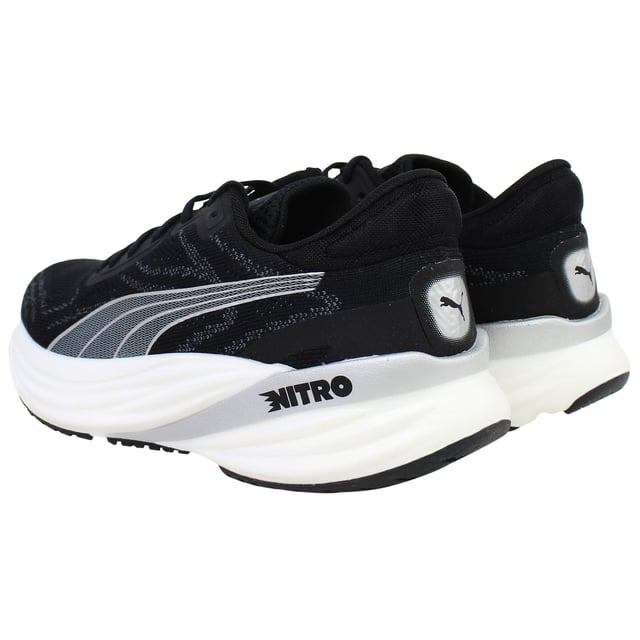 Puma Magnify Nitro 2 Womens Black Running Shoes The PUMA Magnify NITRO 2 Women’s Black is a high-stack, max‑cushioned trainer crafted for daily miles and long-distance comfort. Featuring full-length NITRO foam and a grippy outsole, these shoes deliver soft, responsive cushioning with standout traction and durability. With its sleek black colorway, engineered knit upper, and supportive feel, this edition offers both performance and everyday style.
Key Features
Full-Length NITROFOAM™ Midsole
Puma’s nitrogen-infused foam delivers plush yet responsive cushioning across the entire footbed—perfect for base miles and recovery runs.
Engineered Knit Upper with PWRTAPE Reinforcements
Premium knit fabric molds to the foot for comfort and breathability, while strategic overlay tape adds structural support and a secure fit.
PUMAGRIP Rubber Outsole with Targeted Coverage
Durable traction zones at key contact areas ensure reliable grip and stability on roads—even in damp conditions.
Generous Stack Height with Smooth Transition
Approximately 40 mm heel, 30 mm forefoot, and a 10 mm drop deliver an elevated, rocker-like gait without stiffness.
Moulded Heel Collar and Padded Tongue
Enhances rear-foot comfort and lockdown, reducing heel slippage and irritation on longer runs.