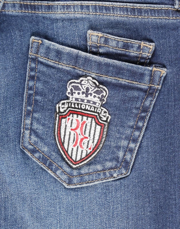 Los clásicos pantalones de denim desgastado de cinco bolsillos son indispensables, incluso en el armario de un niño. Este modelo incluye un botón de metal en la cintura. El bolsillo trasero derecho está adornado con un parche con el icónico emblema de la firma bordado. Corte: Regular.