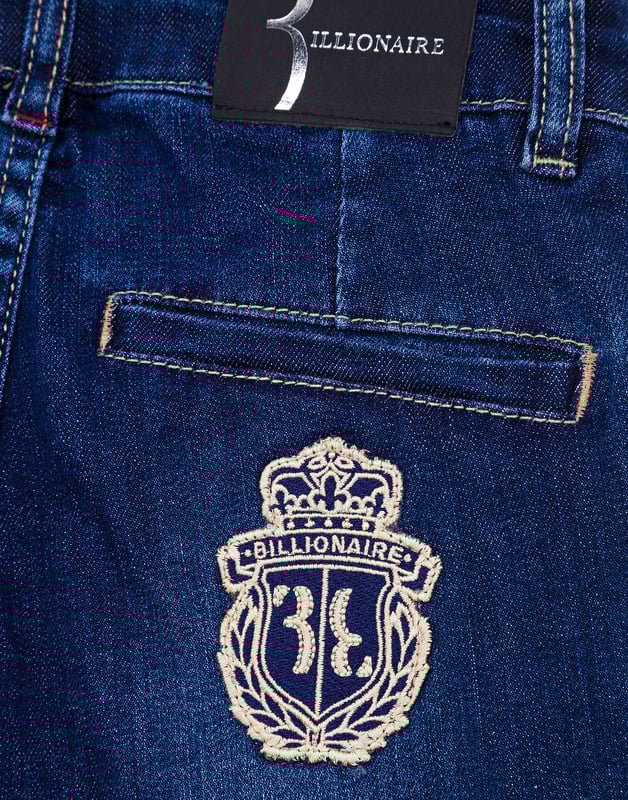La tela de denim desgastada es la que también se emplea en estos clásicos pantalones chinos, otorgándoles una imagen más fresca, apta para la juventud de quienes los llevan. Cuatro bolsillos: dos en la parte frontal y dos insertados en la parte posterior. El parche bordado con el emblema de la firma está cosido debajo del bolsillo trasero derecho. Botonadura de metal en la cintura. Corte: Regular.