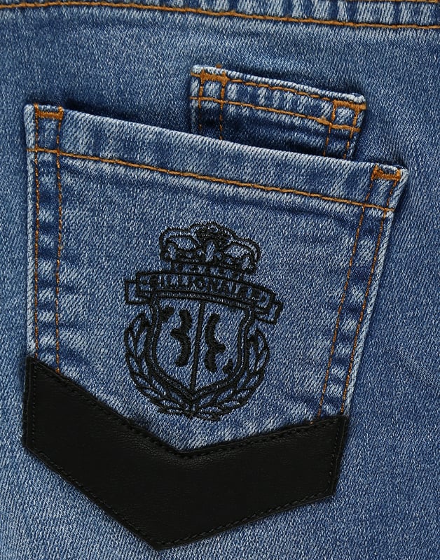 Estos clásicos pantalones de denim con cinco bolsillos es un imprescindible del armario infantil. Este modelo elástico cuenta con detalles de cuero y un cierre con botón único de metal. El emblemático escudo de la firma se presenta bordado en el bolsillo trasero derecho. Corte: Regular.