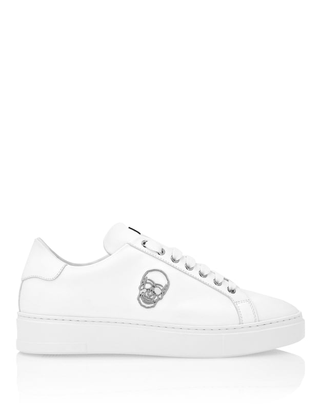 Diese modernen und mutigen Low-Top-Sneaker aus Leder bieten eine Kombination aus elegantem Design und auffälligen Details. Ein Must-have für alle, die Komfort und Luxus zu schätzen wissen.    Low-Top-Silhouette für einen sauberen, zeitgenössischen Look.   Premium-Lederkonstruktion für Haltbarkeit und Komfort.   Totenkopf-Emblem-Details für ein kantiges, ikonisches Finish.   Dicke Gummisohle für verbesserten Komfort und Grip.   Perfekt für lässigen Luxus mit einer unverwechselbaren Einstellung.