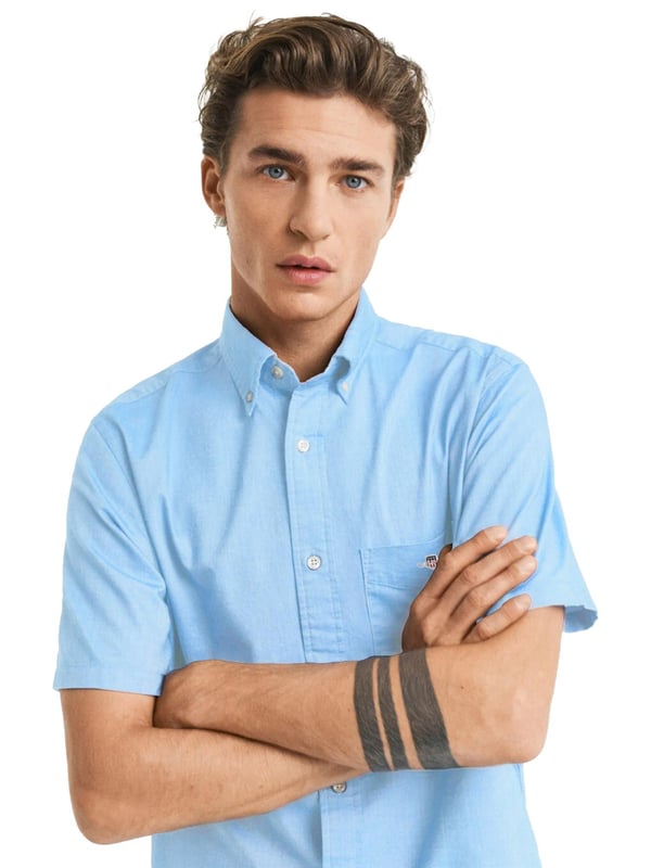 Clásica y versátil, la camisa Oxford es una prenda esencial de estilo smart-casual confeccionada en algodón resistente. Diseñada con corte regular y mangas cortas, es perfecta para los meses más cálidos. Sus detalles incluyen un cuello abotonado, bajo curvado, bolsillo en el pecho con bordado de escudo y una tabla en la espalda con presilla para mayor comodidad y estilo.